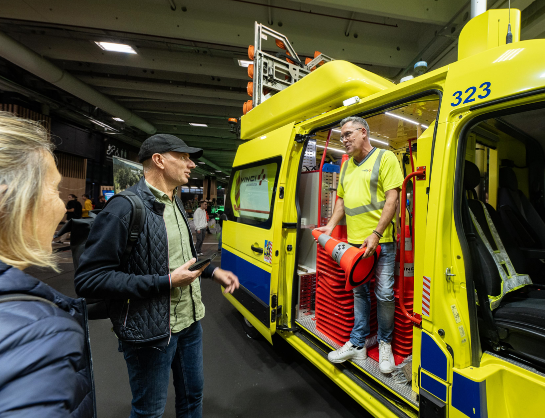 Homme en jaune au contact des visiteurs du salon.