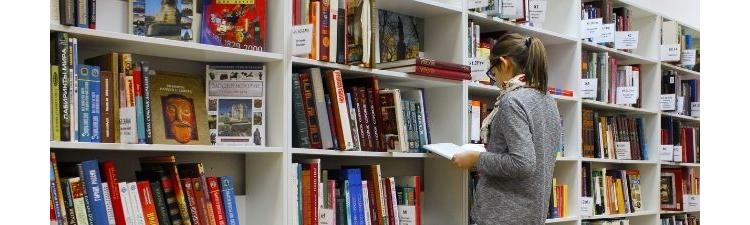 Une personne dans les rayonnages d'une librairie