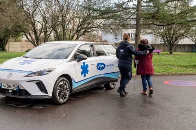 Une collaboratrice de VYV Ambulance aide une personne âgée à monter dans un véhicule