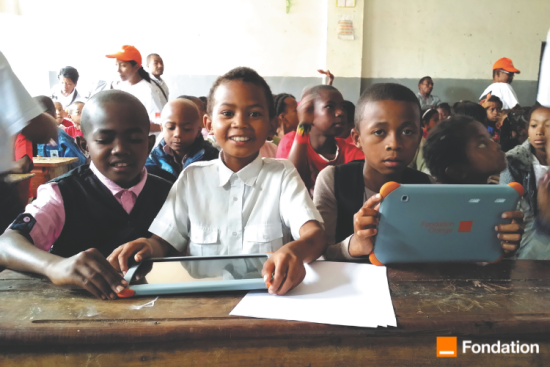 Enfants dans une école avec des tablettes numériques